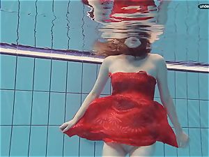 red dressed teenager swimming with her eyes opened